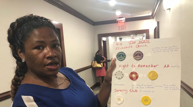 Angela Dalton, 41, of Atlanta shows off Narcotics Anonymous chips she earned after her Friday Aug. 30 hearing at Atlanta Municipal Court. She had been serving her 180 day sentence on prostitution-related charges at a treatment center for women who have experienced sexual exploitation. WILLOUGHBY MARIANO/wmariano@ajc.com