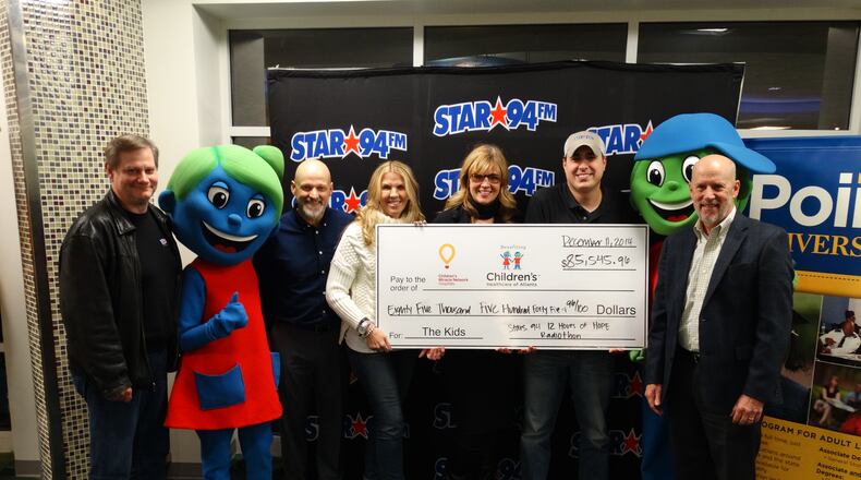 Rob Stadler, Star 94 PD Scotty Lindy, Cindy Simmons, Heather Branch, Rob Marino are among the folks posing in front of the big check after 13 hours of fundraising Thursday. CREDIT: Rodney Ho/rho@ajc.com