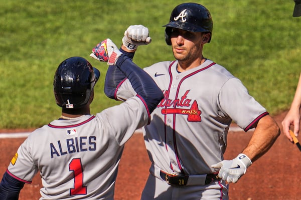 Atlanta Braves' Matt Olson, right, is greeted by Ozzie Albies (1) as he returns to the dugout after hitting a solo home run off Pittsburgh Pirates pitcher Andrew Heaney during the third inning of a baseball game in Pittsburgh, Saturday, May 10, 2025. (AP Photo/Gene J. Puskar)