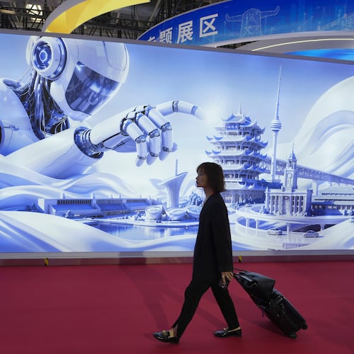 A woman passes a mural depicting a humanoid robot towering over iconic landmarks at the China International Supply Chain Expo in Beijing on Monday, June 22, 2026. (AP Photo/Ng Han Guan)