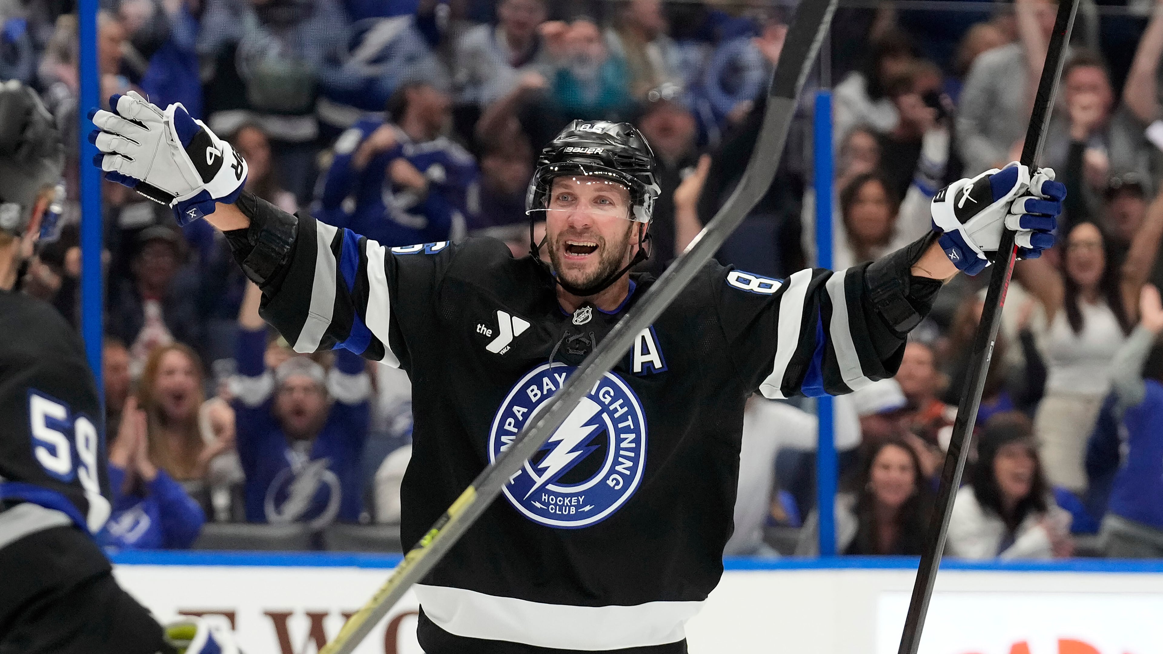 Tampa Bay Lightning right wing Nikita Kucherov (86) celebrates after picking up assist for his 1,000th career point on a goal by center Brayden Point during the second period of an NHL hockey game against the Anaheim Ducks Saturday, Oct. 25, 2025, in Tampa, Fla. (AP Photo/Chris O'Meara)