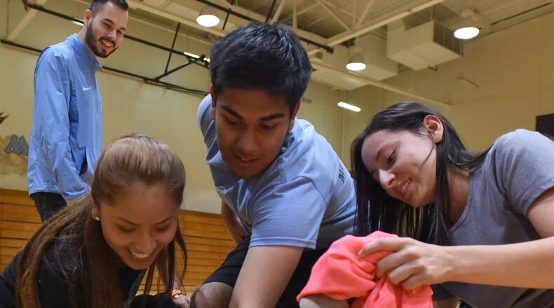 Participants (from left) Cinthia Perez, Tauheed Islam and Jennifer Aguilar compete to choose outfits during a H.O.P.E. workshop (Hispanic Organization Promoting Education) to learn how to dress and speak in interviews at Meadowcreek High School on Thursday, October 15, 2015. It’s all a part of helping each other perform better in school and improve graduation rates. HYOSUB SHIN / HSHIN@AJC.COM
