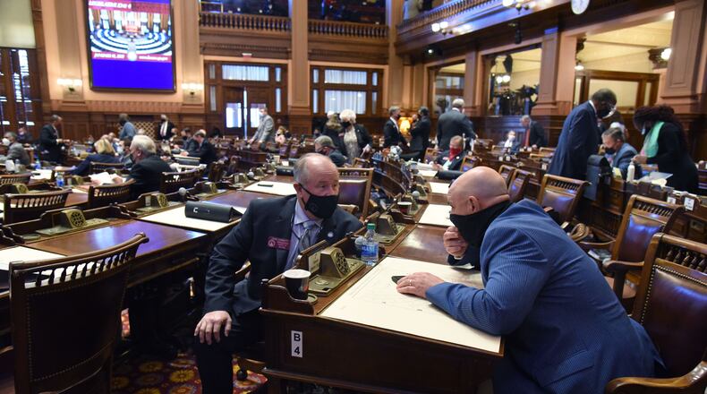State Rep. John Corbett, left, and state Rep. Jason Ridley confer in the House Chambers during the 2021 legislative session at the Georgia Capitol. (Hyosub Shin / Hyosub.Shin@ajc.com)