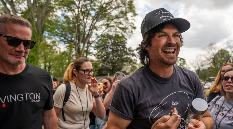 Ian Somerhalder, who played Damon Salvatore on “The Vampire Diaries,” fist-pumps fans as he exits the stage at the Epic conference in Covington earlier this month. The multi-day event celebrates the show’s legacy and its impact on the local community. (Olivia Bowdoin for the AJC)