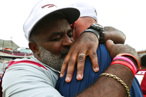 Florida State associate head coach/defensive tackles coach Odell Haggins, left, hugs Georgia Tech quarterbacks coach Chris Weinke after an NCAA college football game Saturday, Oct. 29, 2022, in Tallahassee, Fla. Weinke was the Heisman Trophy-winning quarterback for Florida State in 2000. Florida State won 41-16. (AP Photo/Phil Sears)