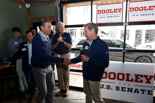 Gov. Brian Kemp (right) welcomes U.S. Senate hopeful Derek Dooley during a campaign event in downtown Carrollton on Monday. (Miguel Martinez/AJC)