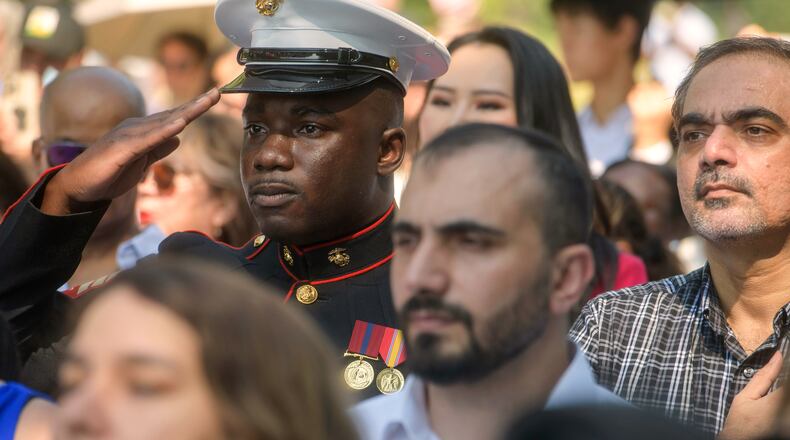 U.S. Marine Sgt. Diakaria Sangare, center, from Guinea, salutes the playing of the national anthem at a naturalization ceremony on Independence Day at George Washington's Mount Vernon, Saturday, July 4, 2026, in Alexandria, Va. (AP Photo/Rod Lamkey, Jr.)