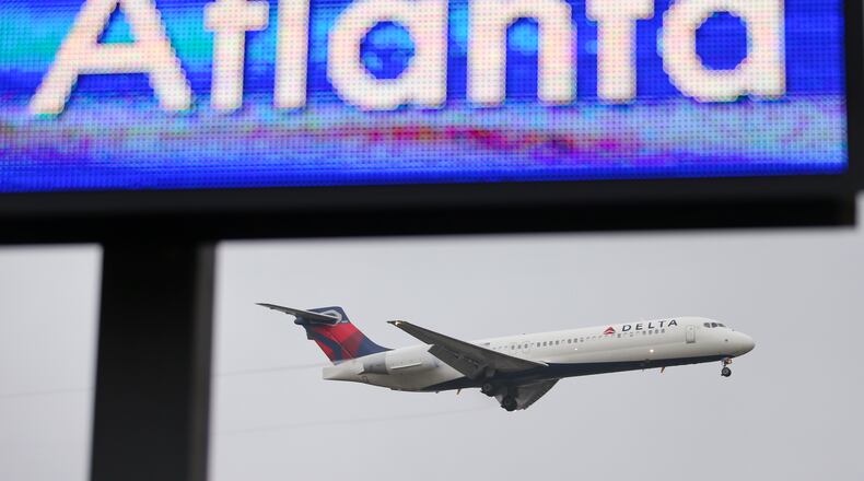 Secondary photo - January 14, 2015 Hartsfield-Jackson International Airport: A Delta jet lands under an electronic board of Atlanta Mayor Kasim Reed welcoming visitors to Atlanta on Wednesday, Jan. 14, 2015. Hartsfield-Jackson International Airport has lost one of its two titles for world's busiest airport, with Chicago O'Hare taking the title for the most flights, according to year-end data from Flight Aware. Atlanta still carries millions more passengers, but for many years it held both titles. The decline in takeoffs and landings in Atlanta came as Delta Airlines retires regional jets and replaces them with larger planes, while Southwest Airlines cut back on AirTran flights here. JOHN SPINK / JSPINK@AJC.COM
