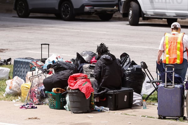 A homeless man sits near his belongings as a cleanup crew clears the homeless encampment on Pryor Street in Atlanta on Monday, May 5, 2025. (Natrice Miller/AJC)