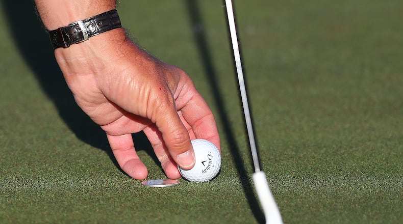 That's Phil Mickelson's left hand replacing his marked ball on an Augusta National green. Even during a practice round, you're expected to perform this act honorablyi. (Curtis Compton/ccompton@ajc.com)