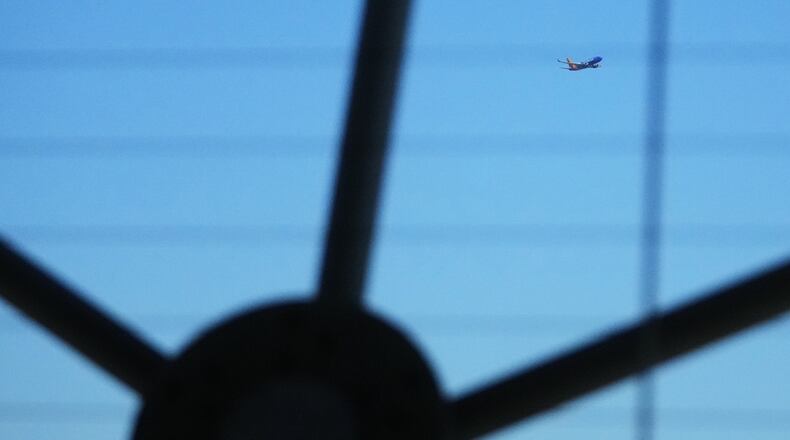 A Southwest Airlines airplane is seen through the structure at Reunion Tower as it flies over Dallas after taking off from Dallas Love Field Airport Thursday, Nov. 6, 2025. (AP Photo/Julio Cortez)
