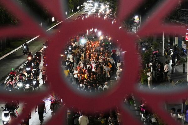 Children hold torches as they parade to celebrate the eve of Eid al-Fitr, the holiday marking the end of the holy fasting month of Ramadan, on a street in Jakarta, Indonesia, Sunday, March 30, 2025. (AP Photo/Dita Alangkara)