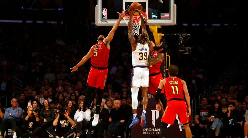 LOS ANGELES, CALIFORNIA - NOVEMBER 17: Dwight Howard #39 of the Los Angeles Lakers goes up to dunk as he's guarded by Jabari Parker #5 and DeAndre' Bembry #95 of the Atlanta Hawks during the first half of a game at Staples Center on November 17, 2019 in Los Angeles, California. NOTE TO USER: User expressly acknowledges and agrees that, by downloading and or using this photograph, User is consenting to the terms and conditions of the Getty Images License Agreement. (Photo by Katharine Lotze/Getty Images)