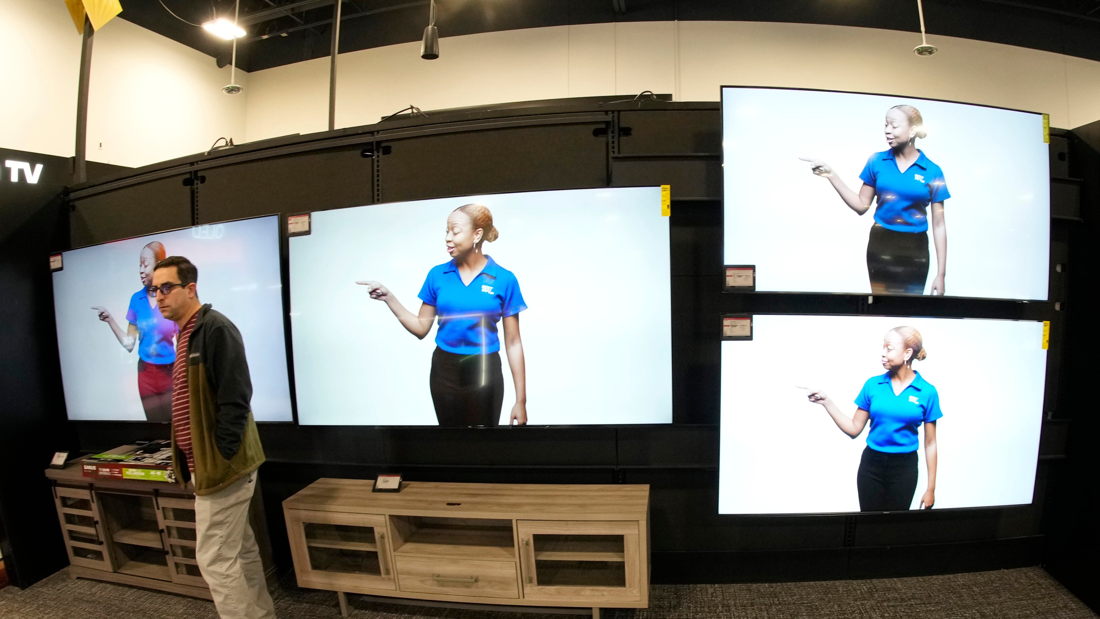 FILE - A customer turns away after looking at big-screen televisions on display in a Best Buy store, Nov. 21, 2023, in southeast Denver. (AP Photo/David Zalubowski, file)