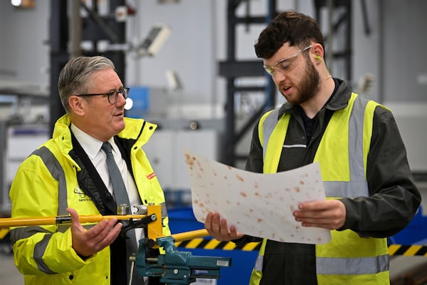 Britain's Prime Minister Keir Starmer, left, speaks to a member of staff during a visit to the BAE Systems'Govan facility, in Glasgow, Scotland, Monday June 2, 2025. (Andy Buchanan, Pool Photo via AP)