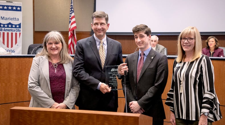 Elise Goldstein, left, stands beside her husband and former Marietta Ward 7 Councilman Philip Goldstein as he receives the Georgia Municipal Association Lifetime Service Award from their son, Marietta Ward 7 Councilman Joseph Goldstein, and GMA official Kay Love. (Courtesy of the city of Marietta)