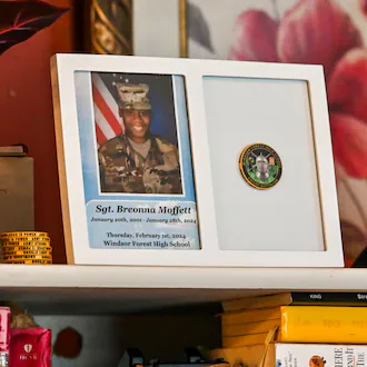 Mementos of Sgt. Breonna Moffett line a shelf at Francine and Percell Moffett's family home in Savannah. (Sarah Peacock for the AJC)