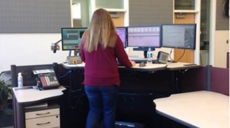 A Gwinnett County 911 dispatcher walks on a treadmill. The communications office director recently purchased two treadmills to promote fitness among the dispatchers.