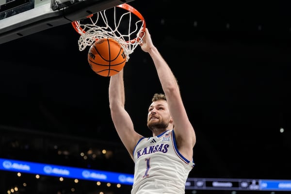 Kansas' Hunter Dickinson (1) dunks during overtime of an NCAA college basketball game against UCF in the second round of the Big 12 Conference tournament, Wednesday, March 12, 2025, in Kansas City, Mo. (AP Photo/Charlie Riedel)