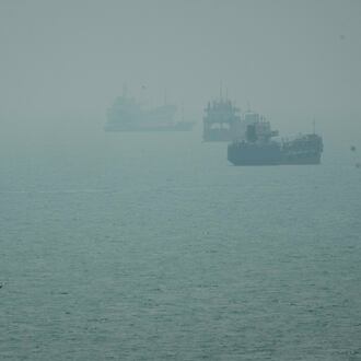 A motorboat travels past commercial vessels anchored amid haze in the Strait of Hormuz off Bandar Abbas, Iran, Monday, Sept. 7, 2026. (AP Photo/Vahid Salemi)