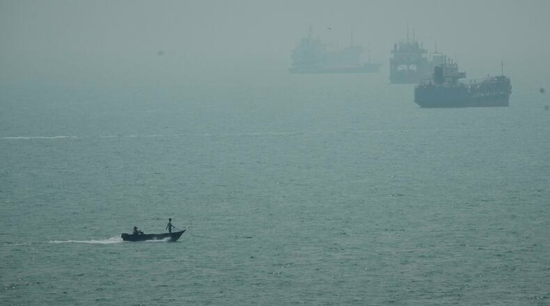 A motorboat travels past commercial vessels anchored amid haze in the Strait of Hormuz off Bandar Abbas, Iran, Monday, Sept. 7, 2026. (AP Photo/Vahid Salemi)