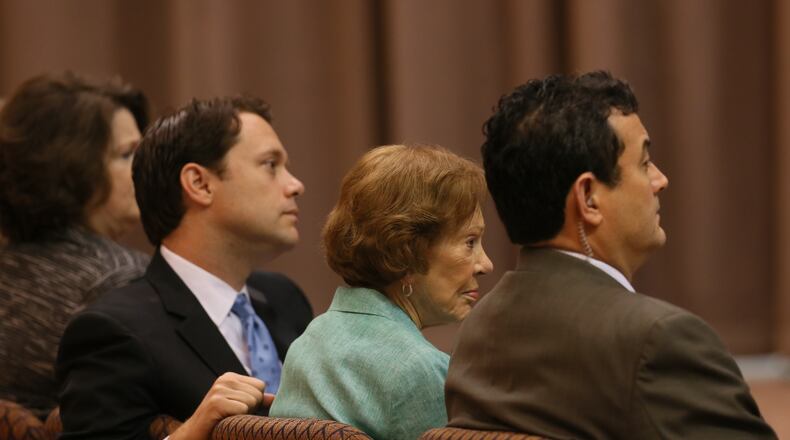 Rosalynn Carter, wife of Jimmy Carter, and his grandson Jason Carter listen during a news conference as the former president discusses his cancer treatment.
