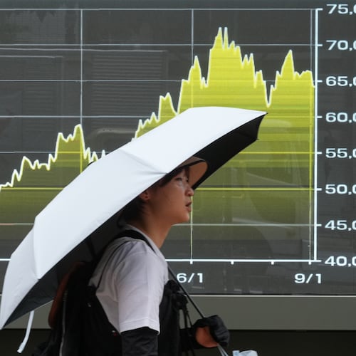 A person walks in front of an electronic stock board showing Japan's Nikkei index at a securities firm Friday, Sept. 4, 2026, in Tokyo. (AP Photo/Eugene Hoshiko)