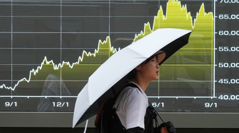 A person walks in front of an electronic stock board showing Japan's Nikkei index at a securities firm Friday, Sept. 4, 2026, in Tokyo. (AP Photo/Eugene Hoshiko)
