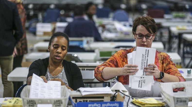 Elections Coordinator, Shantell Black (left) and Elections Deputy Director, Kristi Royston open and scan absentee ballots on Wednesday morning, Nov. 7, 2018 at the Voter Registration and Elections Office at 455 Grayson Hwy, in Lawrenceville. JOHN SPINK/JSPINK@AJC.COM