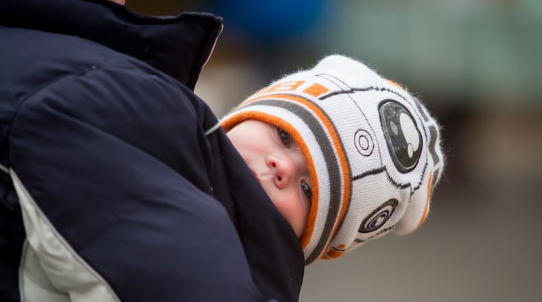 Brittney Shaw tries to keep her young son Rhett warm by tucking him in her jacket while shopping at the Freedom Farmers Market near the Carter Center on Saturday.