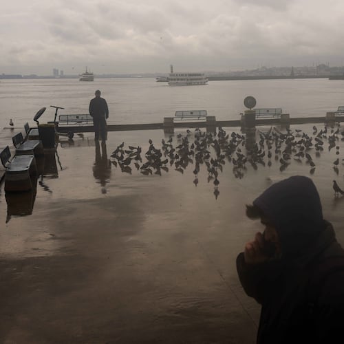 A man stands next to the Bosphorus at Kadikoy ferry terminal on a rainy day in Istanbul, Turkey, Wednesday, April 22, 2026. (AP Photo/Francisco Seco)