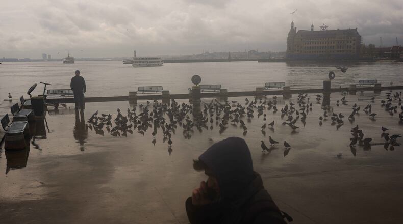 A man stands next to the Bosphorus at Kadikoy ferry terminal on a rainy day in Istanbul, Turkey, Wednesday, April 22, 2026. (AP Photo/Francisco Seco)