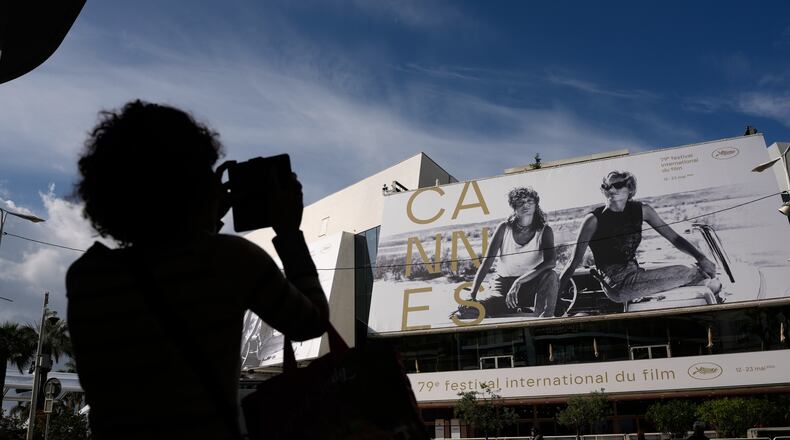 A person takes a photo outside the Palais des Festivals during preparations for the 79th international film festival, Cannes, southern France, Monday, May 11, 2026. (AP Photo/John Locher)