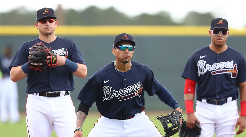 Austin Riley (from left), Johan Camargo and Yangervis Solarte get in some work at third base during Wednesday's activities. (Curtis Compton/ccompton@ajc.com)