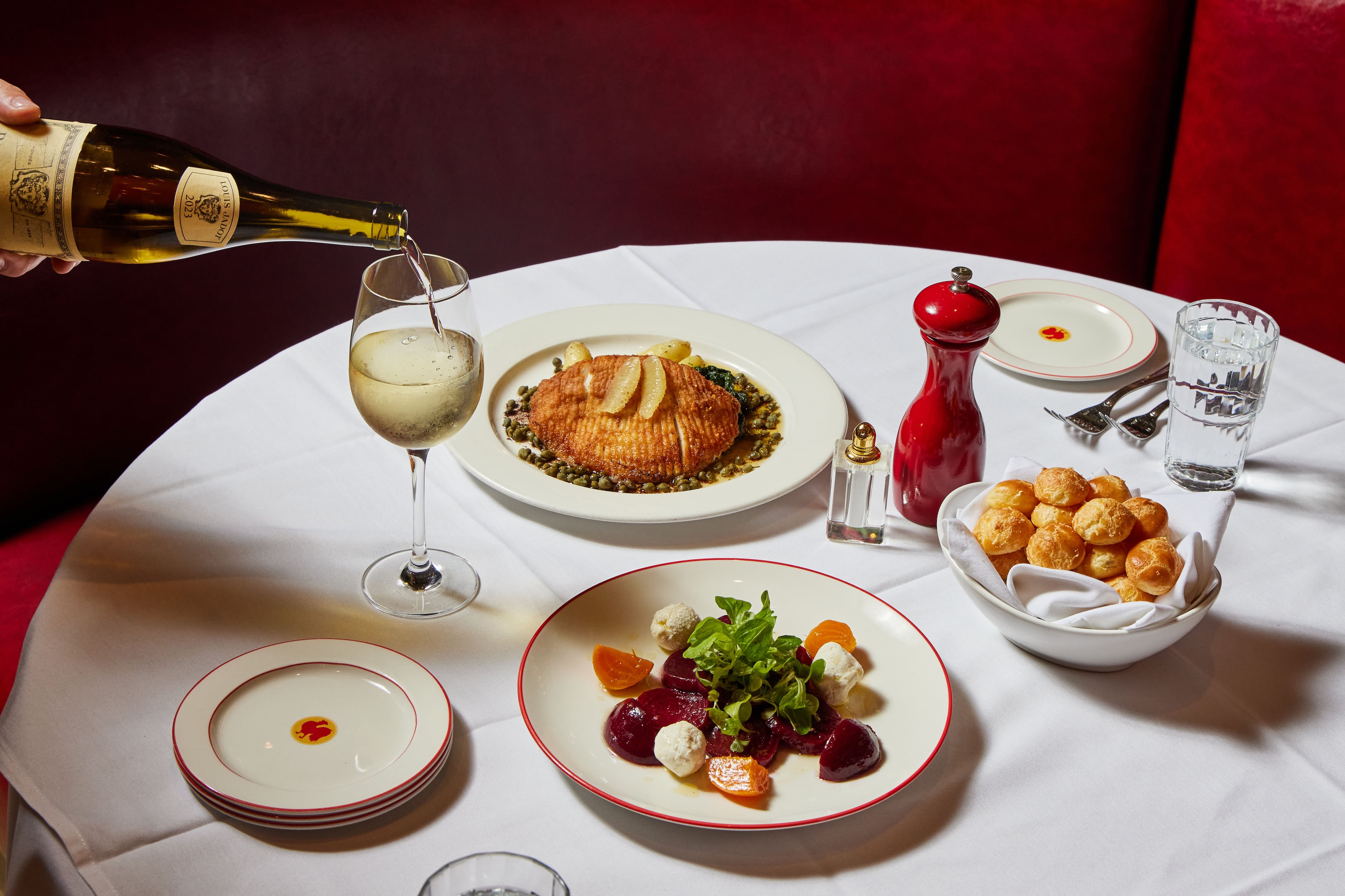 Thanks to Bistro Niko's timeless theme, the food hasn’t gone out of style, including, clockwise from right, gougeres, pickled baby beets with goat cheese salad and skate wing entree. (Styling by Pano Karatassos/ Photo by Bailey Garrot for the AJC.)
