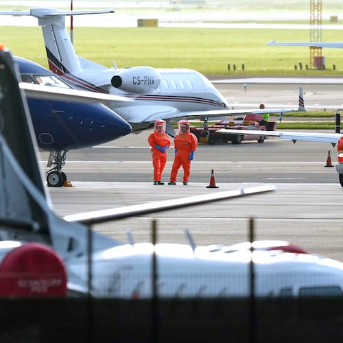 Medical personnel in hazmat suits wait for patients, evacuated from the MV Hondius cruise ship with suspected hantavirus infection, at Schiphol airport, Amsterdam, Netherlands, Wednesday, May 6, 2026. (AP Photo/Peter Dejong)