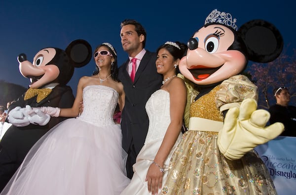 FILE - Actor Cristian de la Fuente, center, poses for photos with Shalmary Arroyo, left, Amethist Martinez, right, and Mickey and Minnie Mouse on the red carpet as 15 young ladies from across the United States and Puerto Rico were given an opportunity celebrate their Quinceañera at Disneyland Resort in Anaheim, Calif., April 24, 2008. (AP Photo/Mark Avery, File)