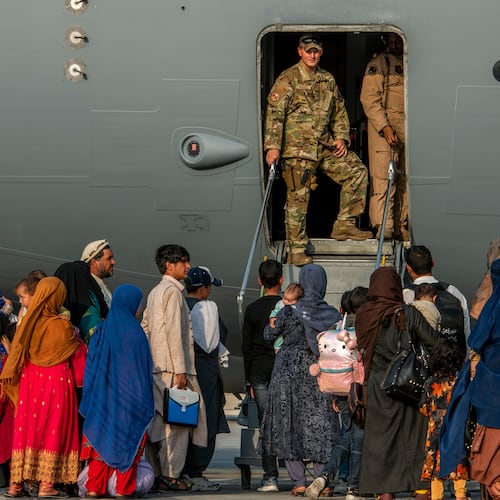 FILE - In this Aug. 22, 2021 file photo provided by the U.S. Air Force, service members stand at a doorway as Afghan evacuees prepare to board an aircraft, Aug. 22, 2021, at Al Udeid Air Base, Qatar. (Airman 1st Class Kylie Barrow/U.S. Air Force via AP, File)