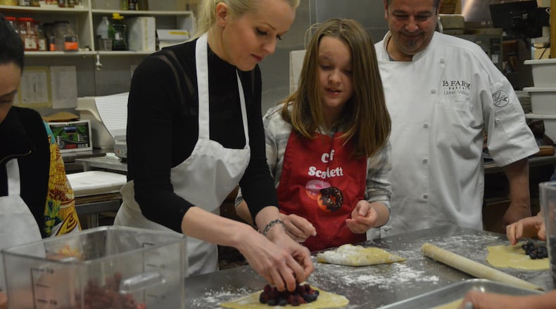 Master baker Lionel Vatinet looks on while students practice baking skills learned at La Farm. (Myscha Theriault/TNS)