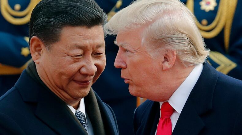 FILE - In this Nov. 9, 2017, file photo, U.S. President Donald Trump, right, chats with Chinese President Xi Jinping during a welcome ceremony at the Great Hall of the People in Beijing. (AP Photo/Andy Wong, File)