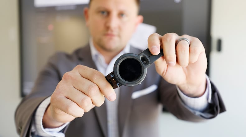Justin Hawkins, CEO of Talitrix, is seen holding one of the company's wristbands. The Alpharetta-based company touts its technology as a cutting edge alternative to bulky ankle monitors. Tuesday, May 2, 2023. Miguel Martinez /miguel.martinezjimenez@ajc.com