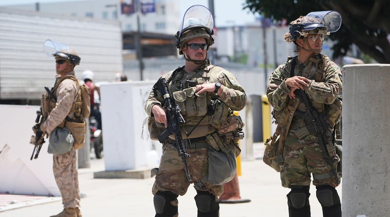 FILE - Members of the California National Guard and U.S. Marines guard a federal building on Tuesday, June 17, 2025, in Los Angeles. (AP Photo/Damian Dovarganes, File)