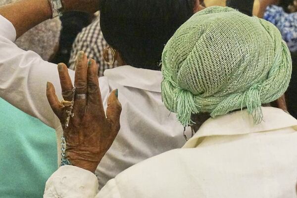 A woman holds a rosary as she prays during an eucharistic adoration event at Notre Dame d'Haiti, the Catholic church at the heart of the Haitian diaspora, March 29, 2025, in Miami. (AP Photo/Giovanna Dell'Orto)