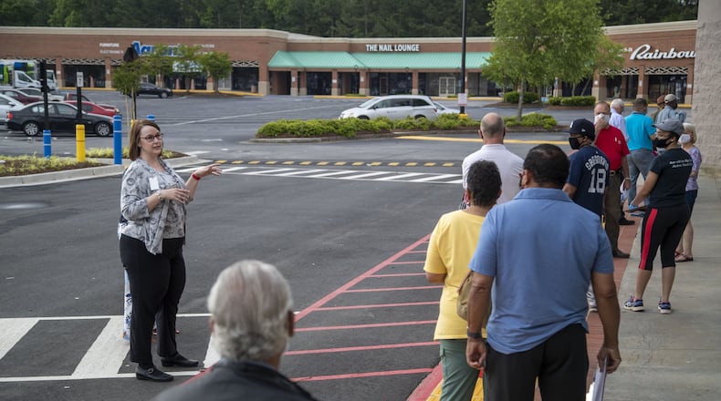 Gwinnett County elections supervisor Kristi Royston (left) gives instructions to individuals waiting in line for early in-person voting at the Gwinnett County Voter Registration and Elections Office in Lawrenceville, Monday, May 18, 2020. (ALYSSA POINTER / ALYSSA.POINTER@AJC.COM) AJC FILE PHOTO