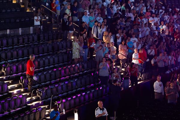 Attendees stand for the national anthem before a Turning Point USA event featuring speakers including Vice President JD Vance at Akins Ford Arena in Athens earlier this month. (Arvin Temkar/AJC)