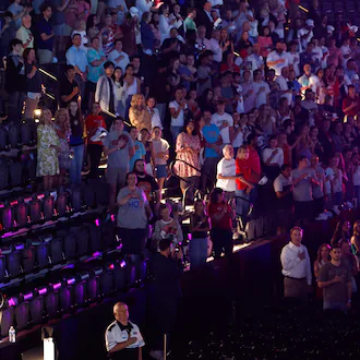 Attendees stand for the national anthem before a Turning Point USA event near the University of Georgia on Tuesday, April 14, 2026. (Arvin Temkar/AJC)