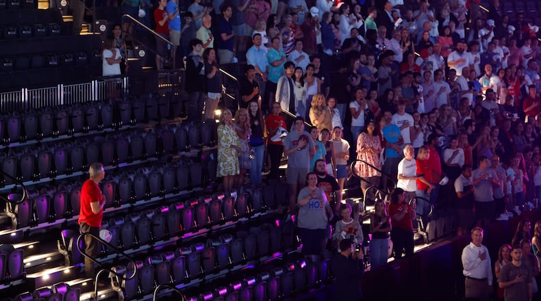 Attendees stand for the national anthem before a Turning Point USA event near the University of Georgia on Tuesday, April 14, 2026. (Arvin Temkar/AJC)