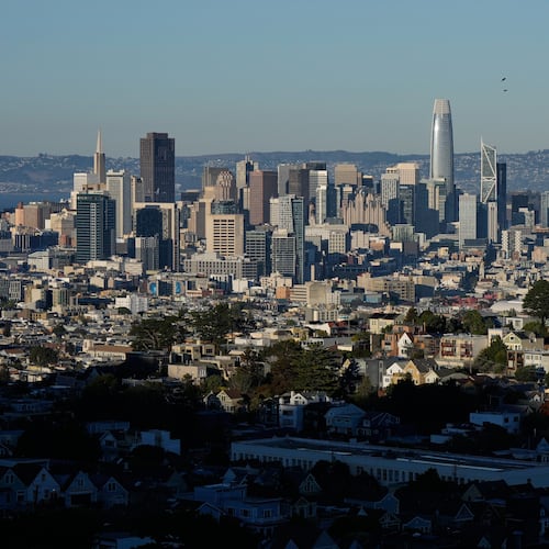 Homes are illuminated by sunlight as the San Francisco skyline is seen in the background, Friday, Oct. 17, 2025, in San Francisco. (AP Photo/Godofredo A. Vásquez)