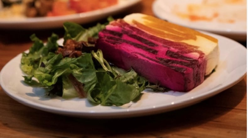 Kindred's beet terrine looks like a technicolor layer cake, with goat cheese stacked between red and gold beets. Courtesy of Alison Jakaitis