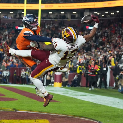 Washington Commanders wide receiver Treylon Burks (13) catches a touchdown pass as Denver Broncos cornerback Riley Moss, left, defends during the second half of an NFL football game Sunday, Nov. 30, 2025, in Landover, Md. (AP Photo/Stephanie Scarbrough)